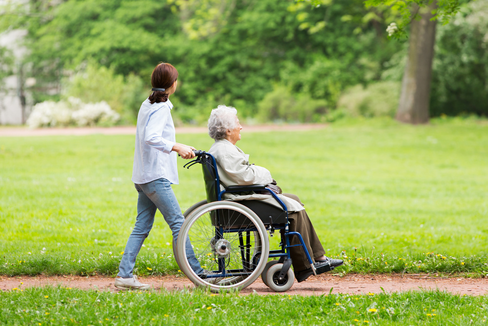Assisted living – caregiver and senior woman on a wheelchair
