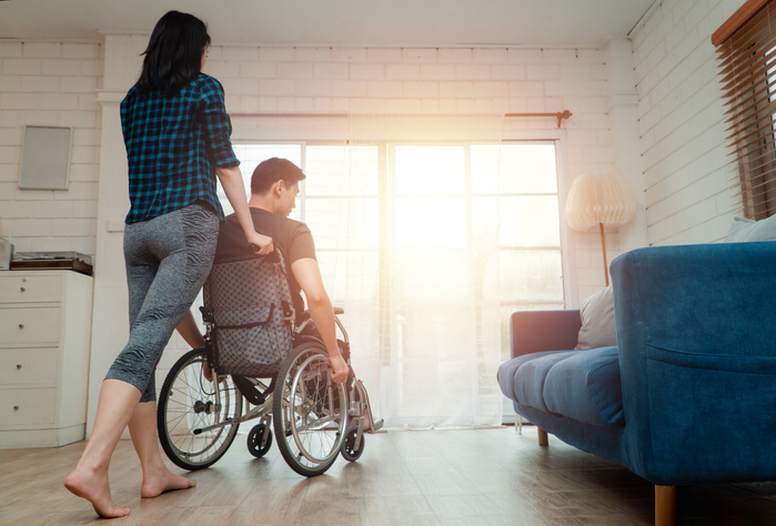 An asian man in a wheelchair in the home after a car acciden